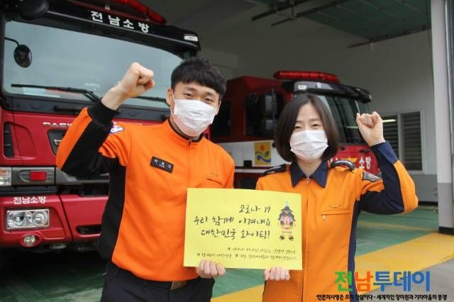 담양소방서 사진제공 고선희 소방장(우)과 박철진 소방사(좌) 대국민 응원 메시지를 들고 파이팅 포즈를 취하고 있다.