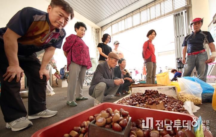 강진읍 시장에서 관광객들이 물건을 고르고 있다