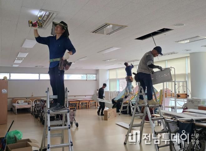 강대표와 전문기술자들이 조명을 교체하고 있다.