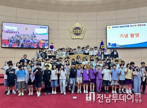 진호건 전남도의원과 곡성중앙초·여수여도초 학생들이 본회의장에서 함께 기념촬영을 하고 있다.