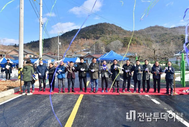 장성읍 잠암마을 주민들이 24일 도로 확포장 공사 준공식을 갖고 자축하고 있다.